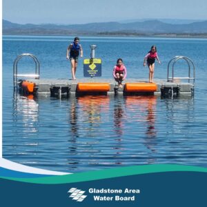 Three children jumping into Lake Awoonga from the swimming pontoon in the water