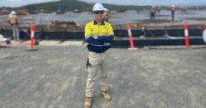 An image of Gladstone Pipeline Construction Manager Jim McGinty standing in front of large black pipes on the Fitzroty to Gladstone Pipeline work site.